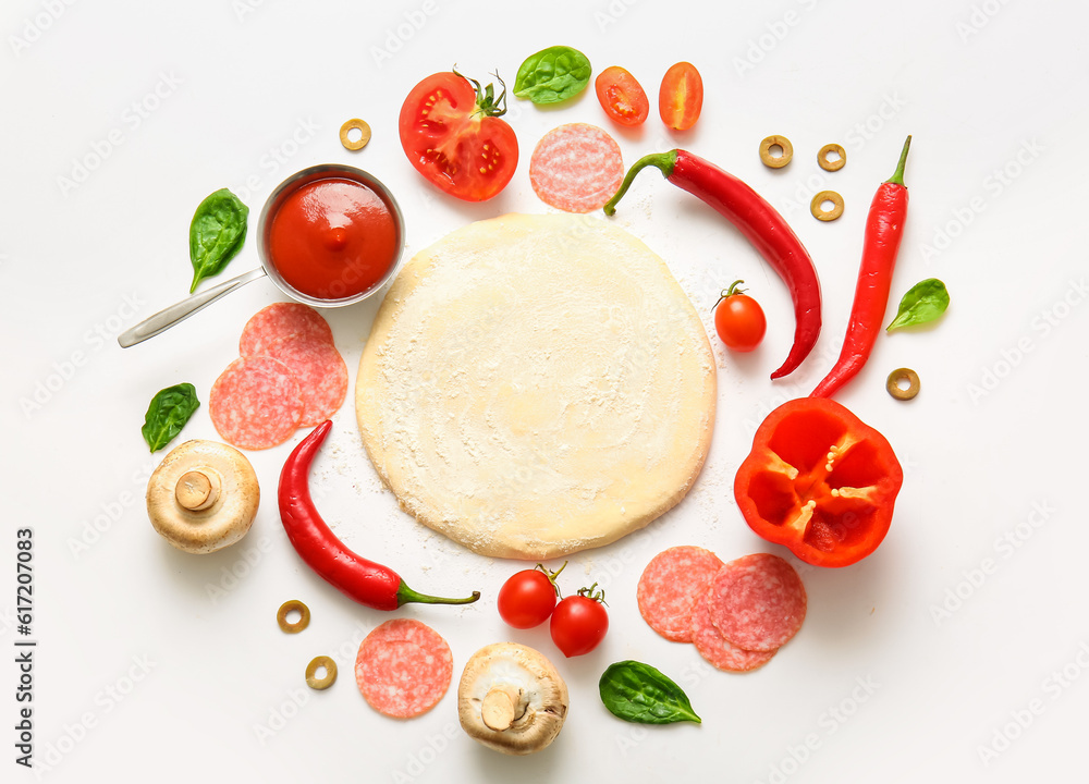 Raw dough and ingredients for preparing pizza on white background