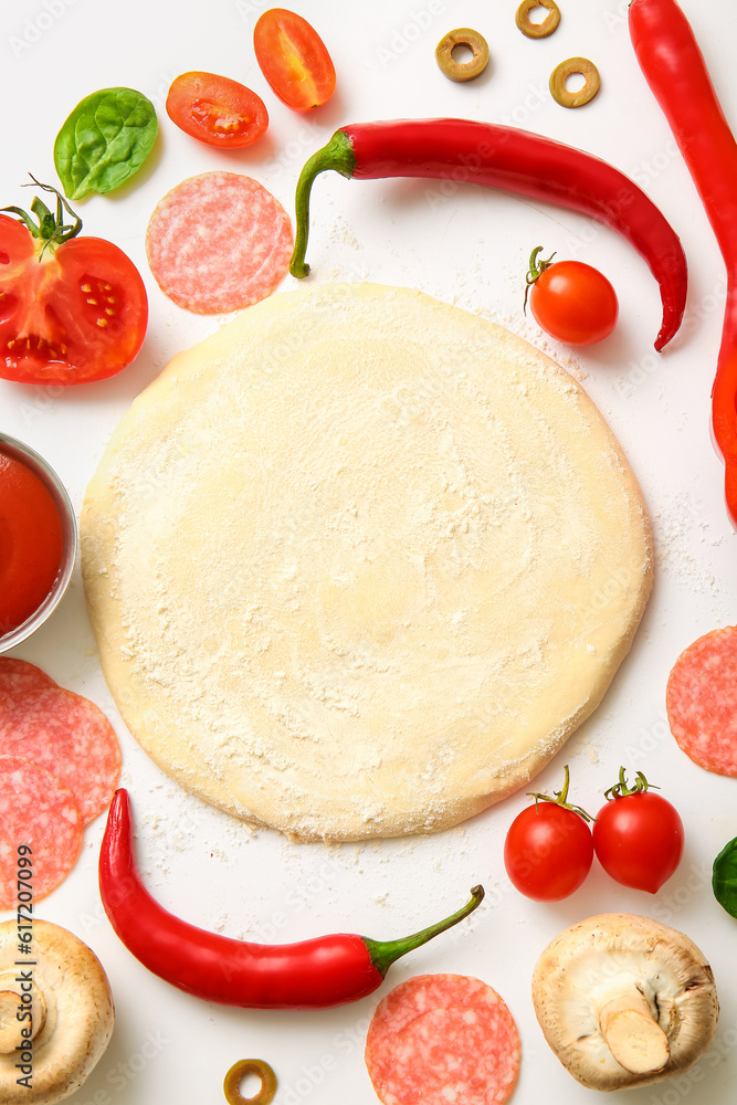 Raw dough and ingredients for preparing pizza on white background