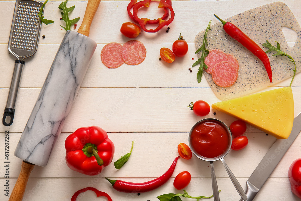 Frame made of ingredients for preparing pizza on light wooden background