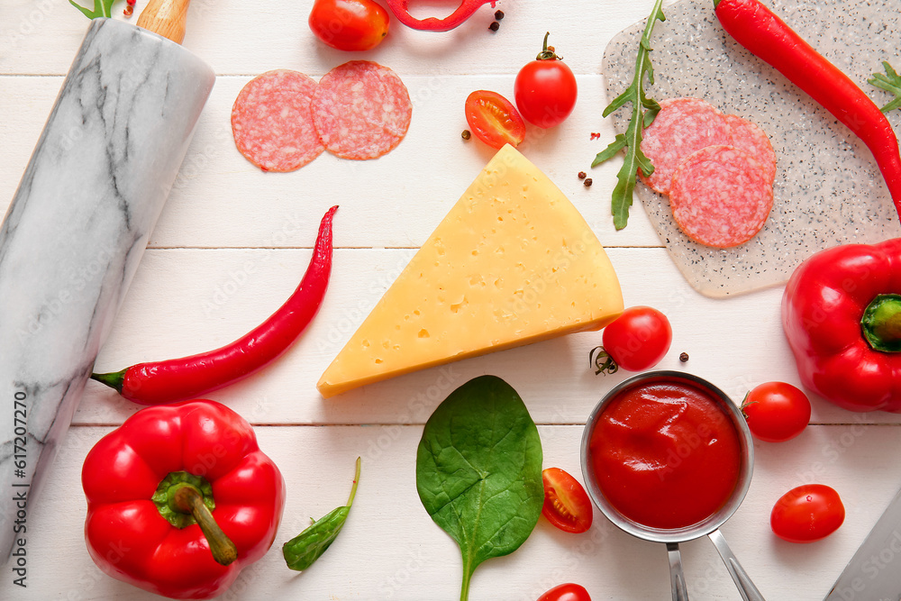 Different ingredients for preparing pizza on light wooden background