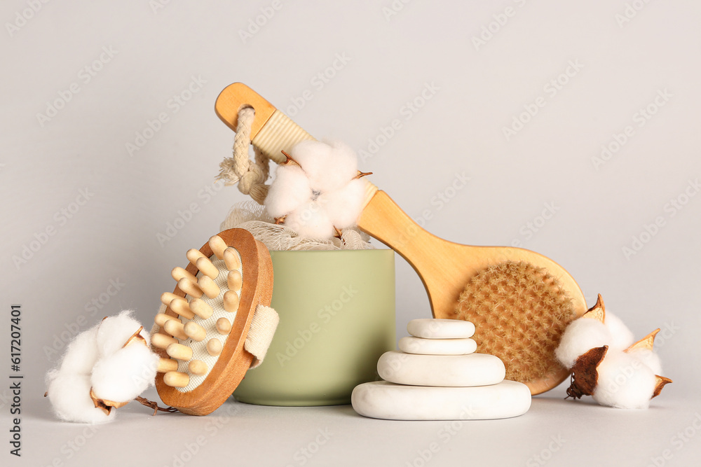 Composition with bath supplies and cotton flowers on grey background