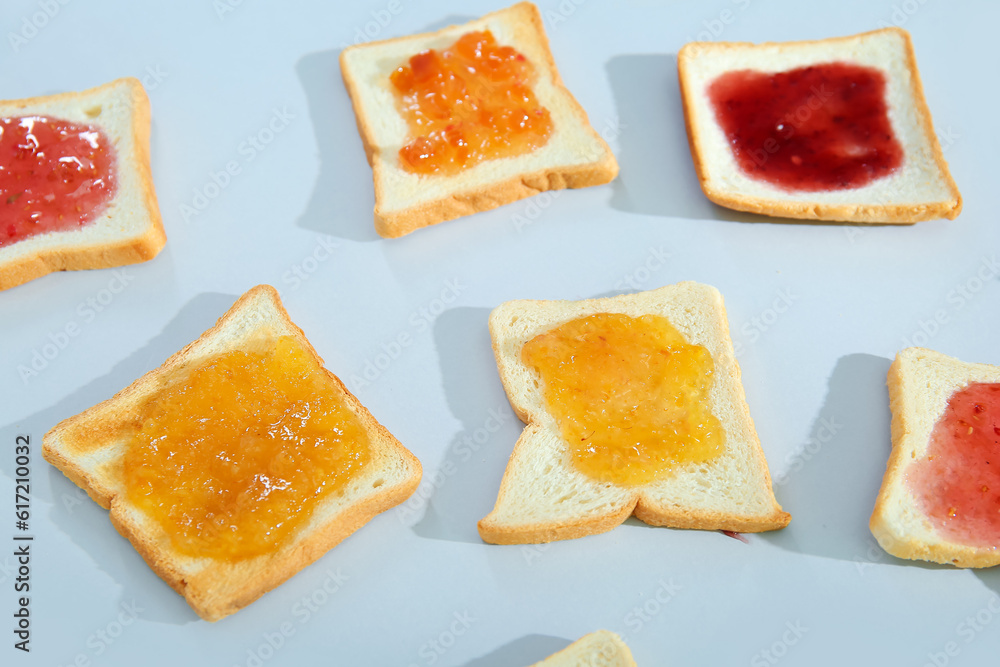 Delicious toasts with different jams on light background, closeup