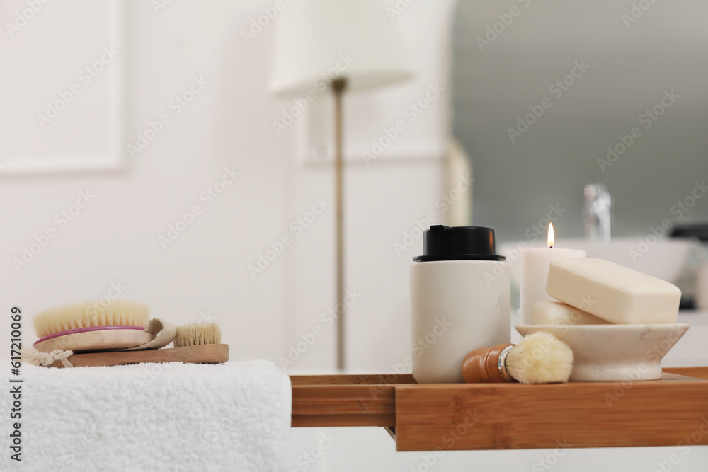 Soap bars, brushes and bath accessories on board in interior of bathroom