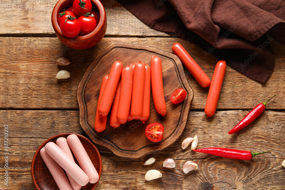 Board with tasty thin sausages on wooden background