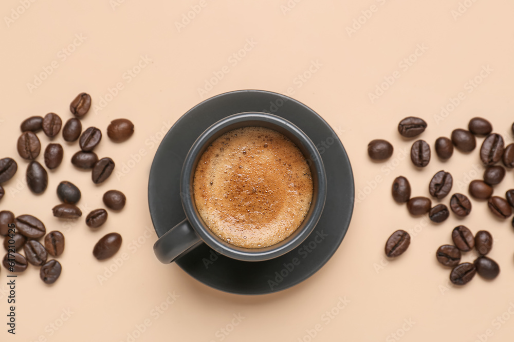 Cup of hot espresso and coffee beans on beige background