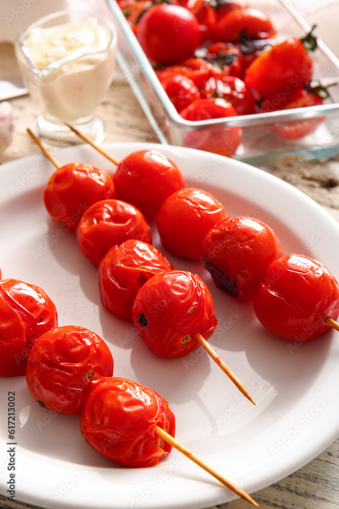 Baking dish and plate with tasty grilled tomatoes, closeup