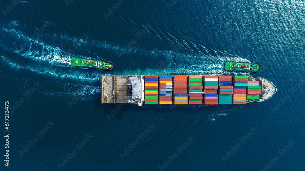 Aerial top view of cargo ship carrying container and running with tug boat for import export goods f