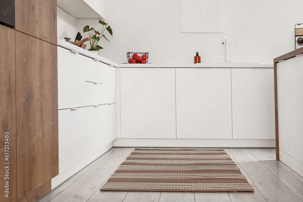 Stylish striped rug in interior of modern kitchen