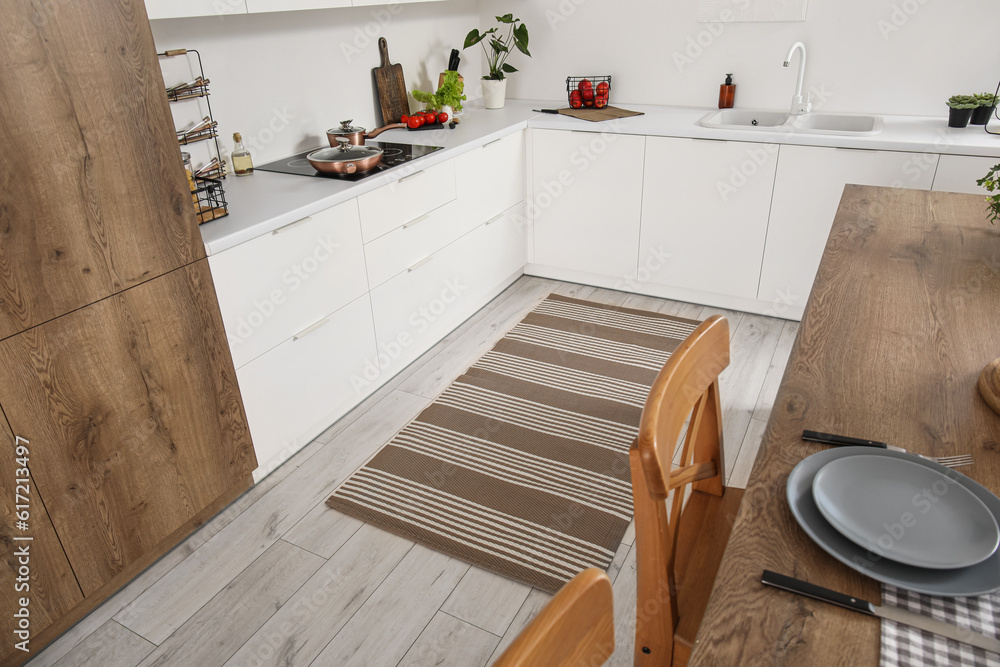 Stylish striped rug in interior of modern kitchen