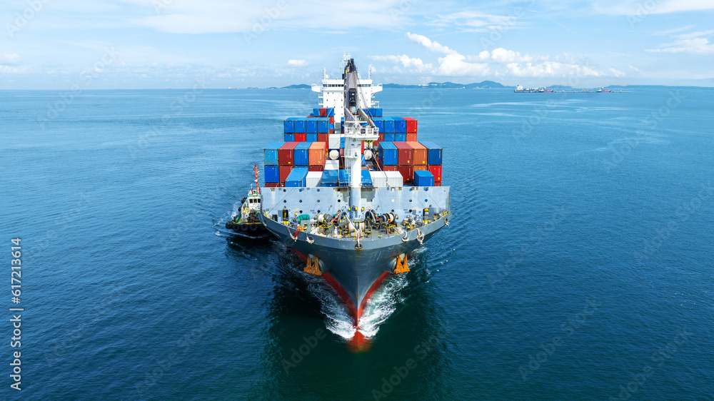 Aerial front view of cargo ship carrying container and running with tug boat for import export goods