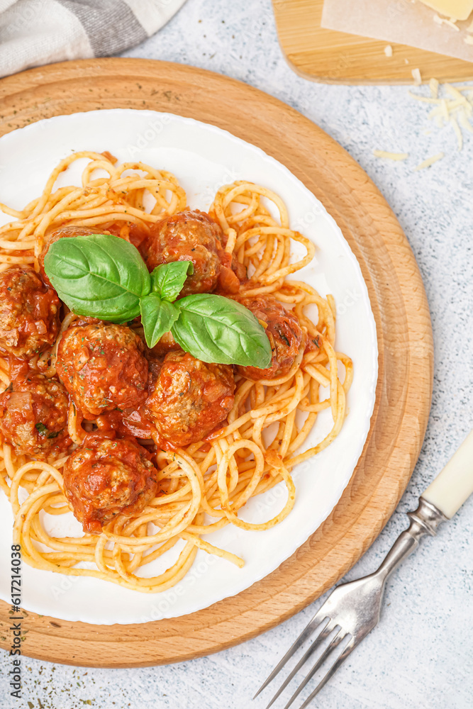 Plate of boiled pasta with tomato sauce and meat balls on white table