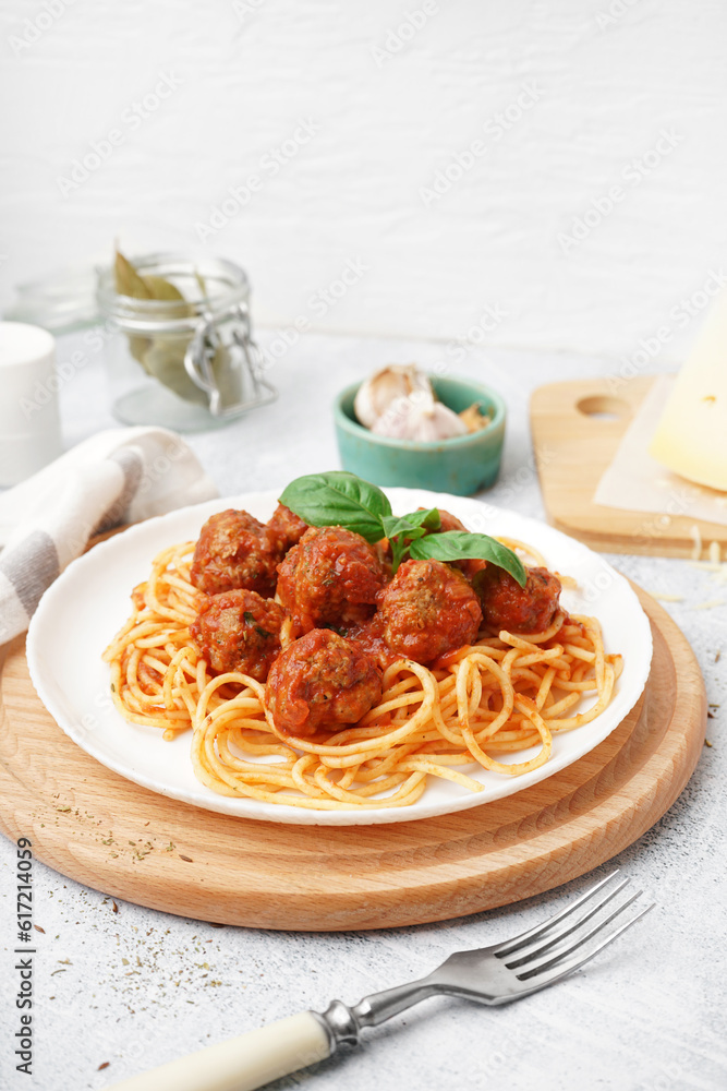 Plate of boiled pasta with tomato sauce and meat balls on white table