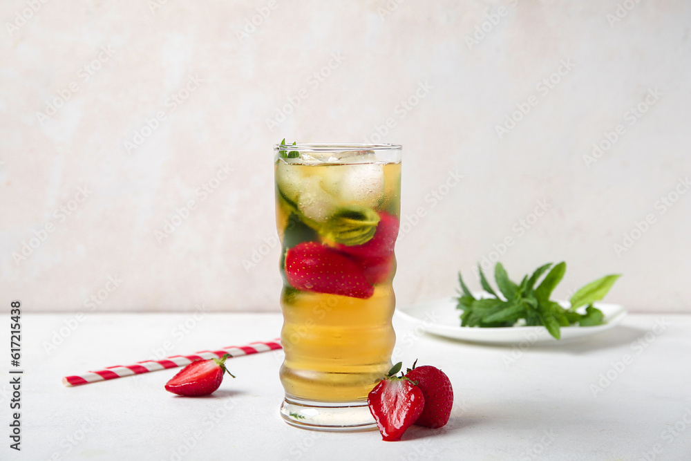 Glass of ice tea with strawberry and mint on white background