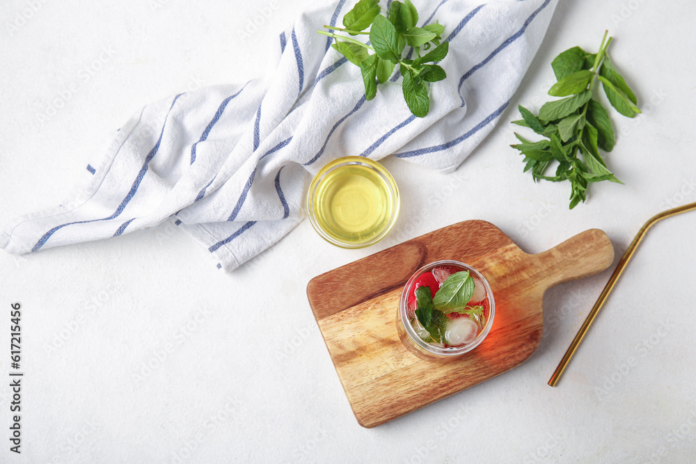 Glass of ice tea with strawberry and mint on white background