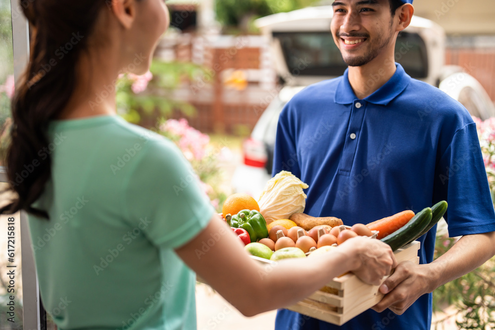 Asian young delivery man delivering package to female customer at home. 