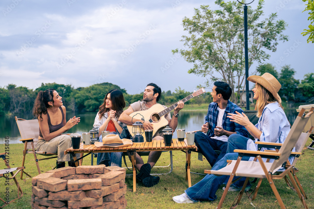 Group of diverse friend having outdoors camping party together in tent. 