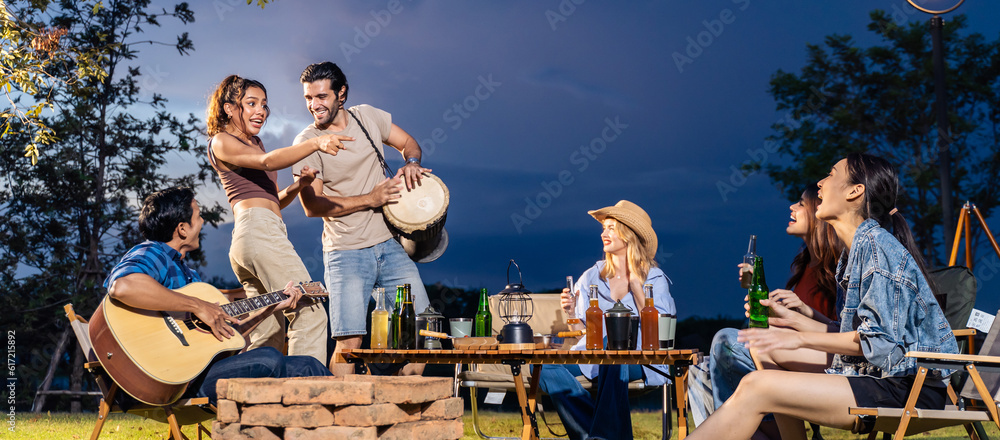 Group of diverse friend having outdoors camping party together in tent. 