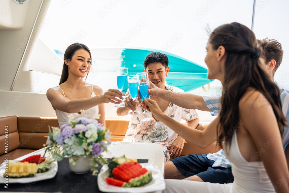 Group of diverse friends drink champagne while having a party in yacht. 