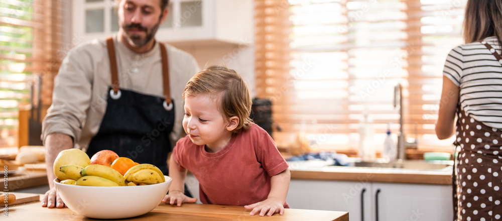 Caucasian attractive couple baking bakery with son in kitchen at home. 