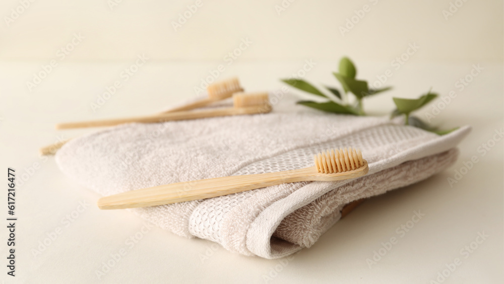 Bamboo tooth brushes and towel on light background