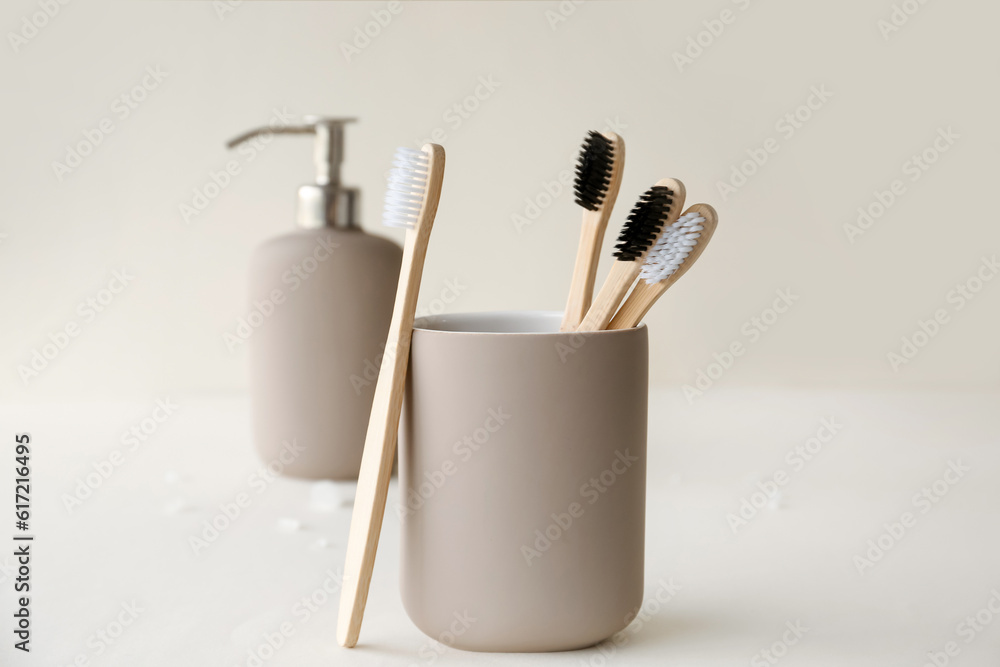 Bamboo tooth brushes in holder on light background