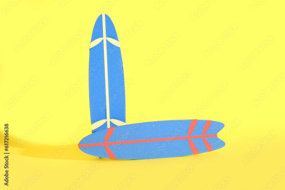 Mini surfboards on yellow background