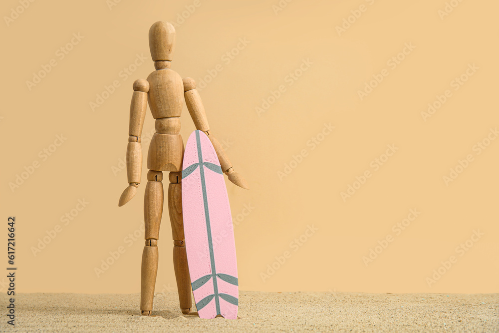 Creative composition with miniature surfboard and wooden mannequin on sand against beige background