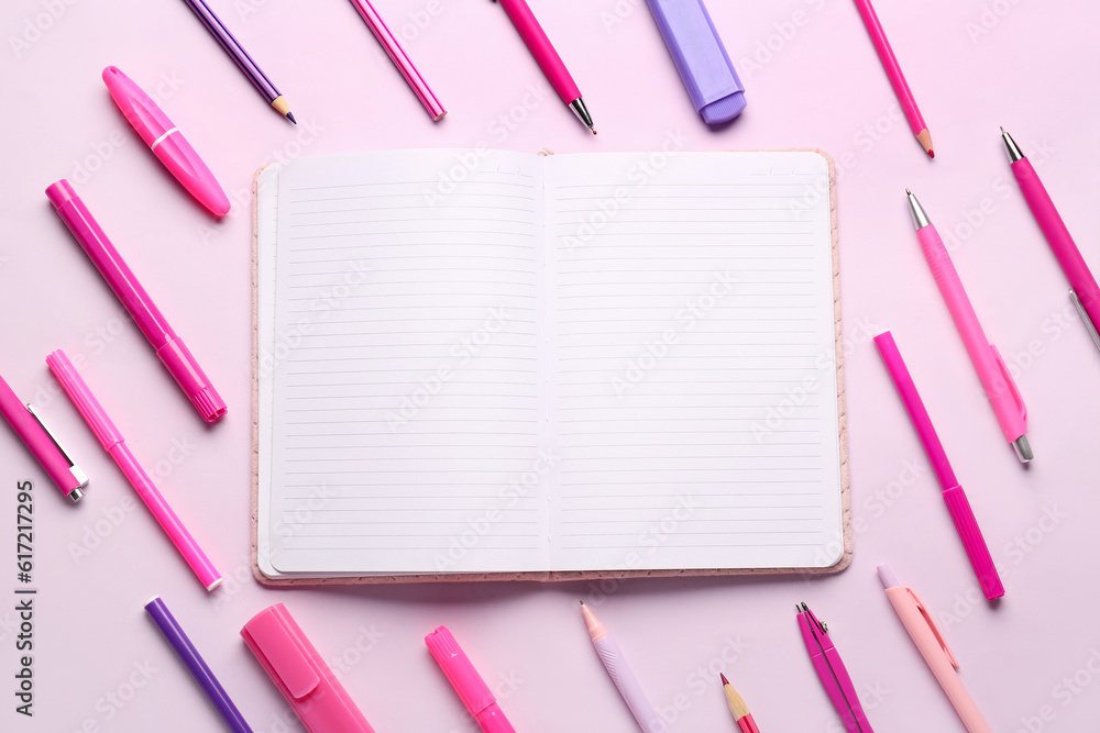 Notebook with different school stationery on lilac background