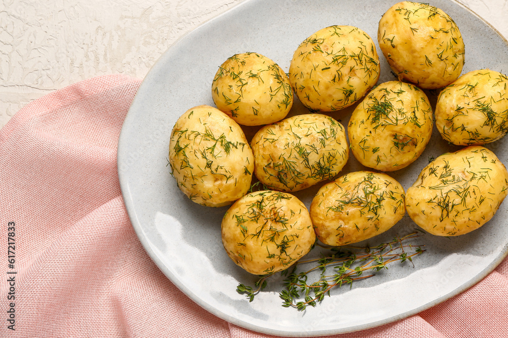 Plate of boiled baby potatoes with dill on white background