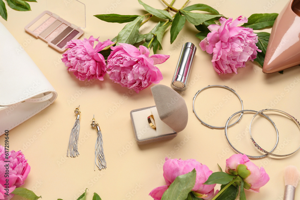 Composition with beautiful engagement ring, stylish accessories, cosmetics and peony flowers on colo