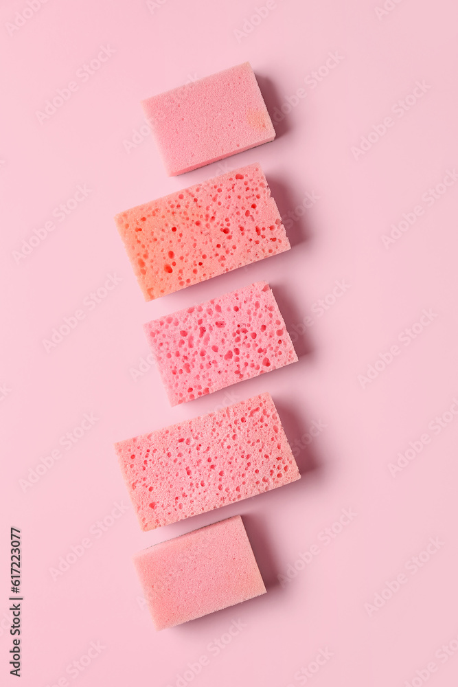 Row of different sponges on pink background