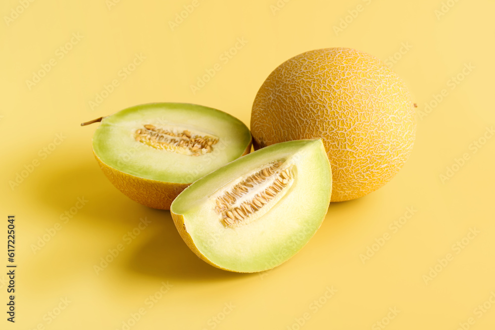 Sweet melon with pieces on yellow background