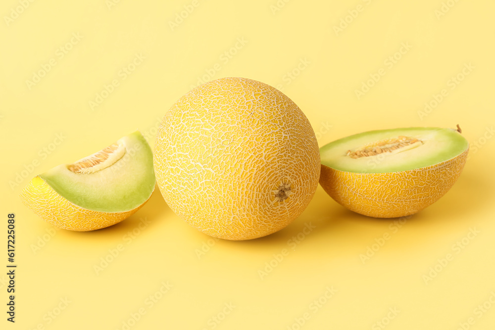 Sweet melon with pieces on yellow background