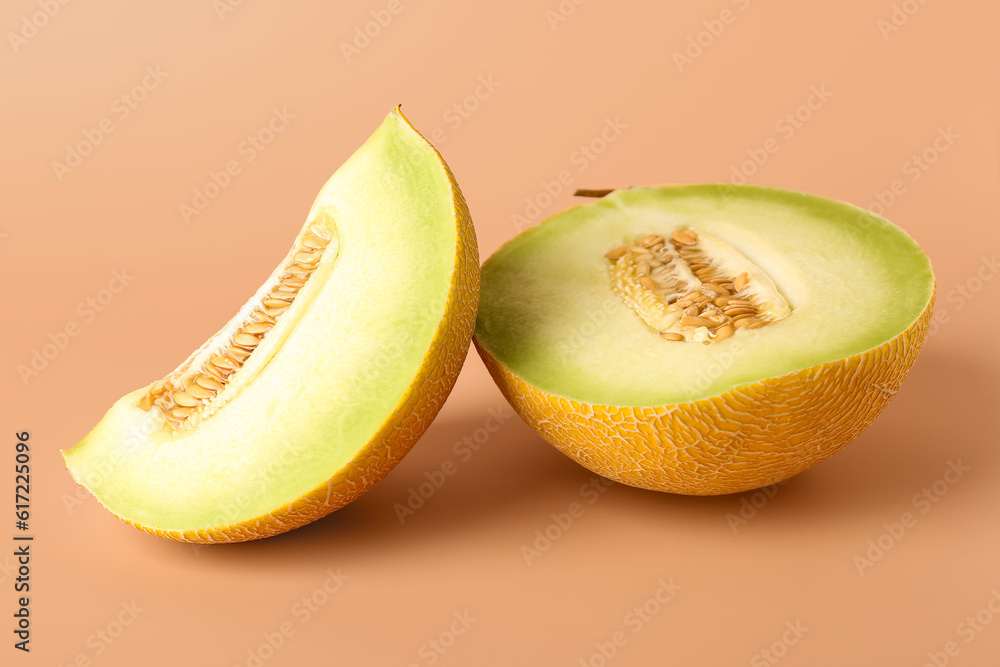 Half of sweet melon with piece on orange background