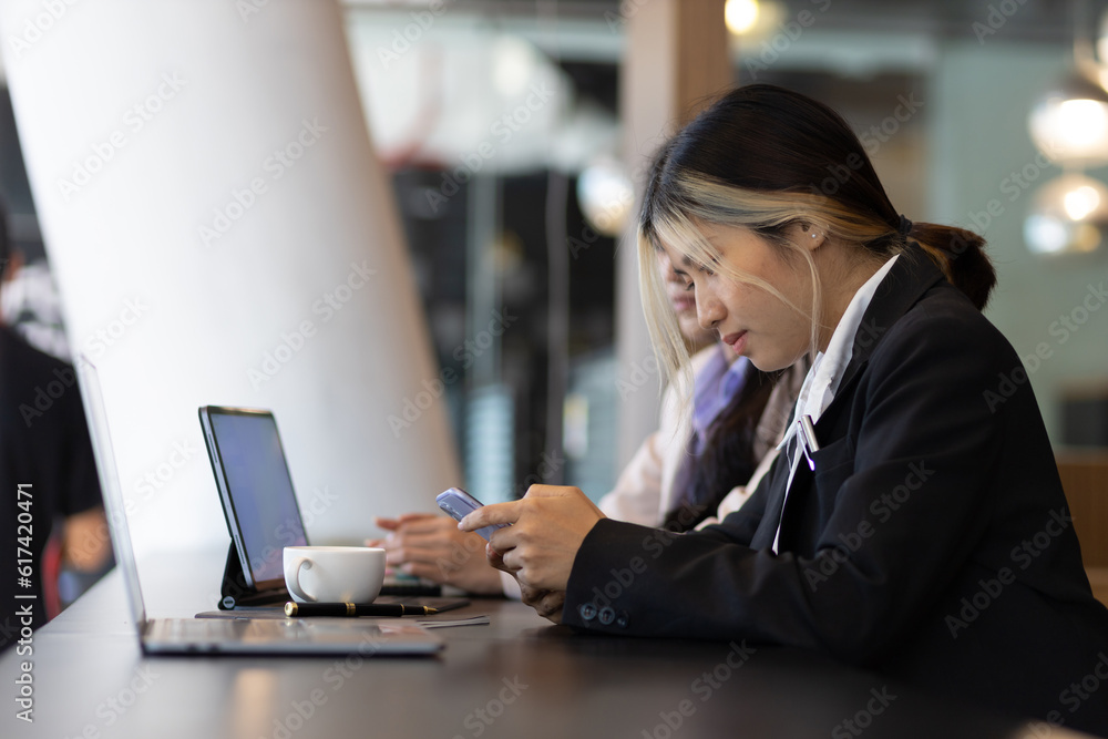 Businesswoman secretary colleague working with laptop in office. Two receptionists working at the co