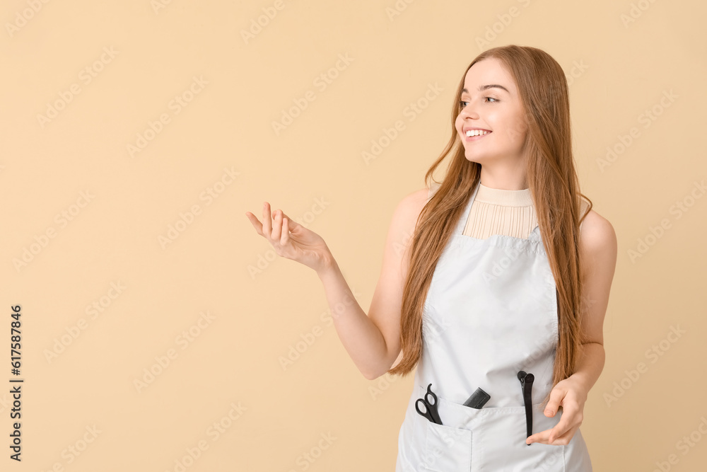 Female hairdresser showing something on beige background