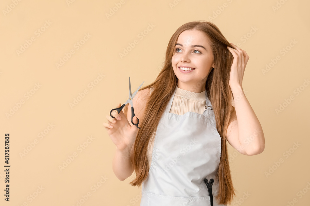 Female hairdresser with scissors on beige background