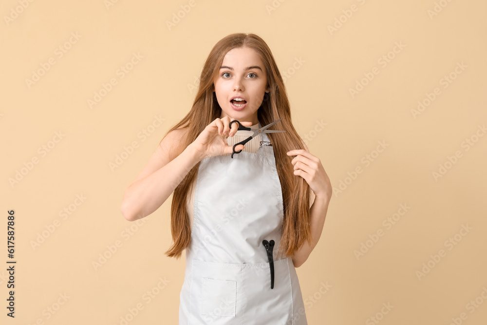 Female hairdresser with scissors on beige background