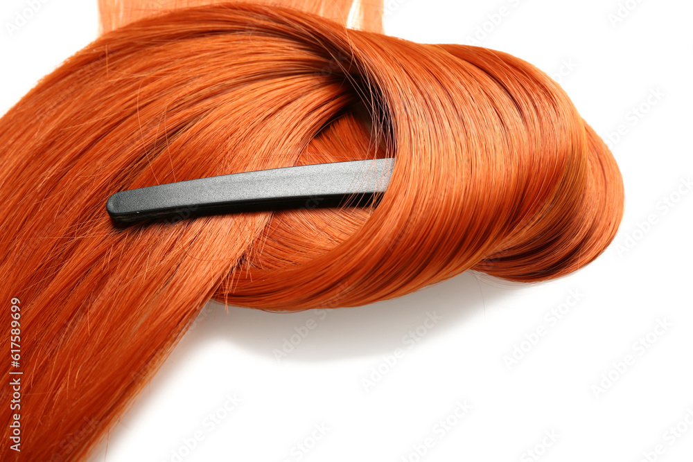 Ginger hair strand and clip on white background, closeup