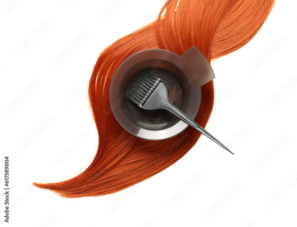 Ginger hair strand, bowl for hair dye and brush on white background, closeup