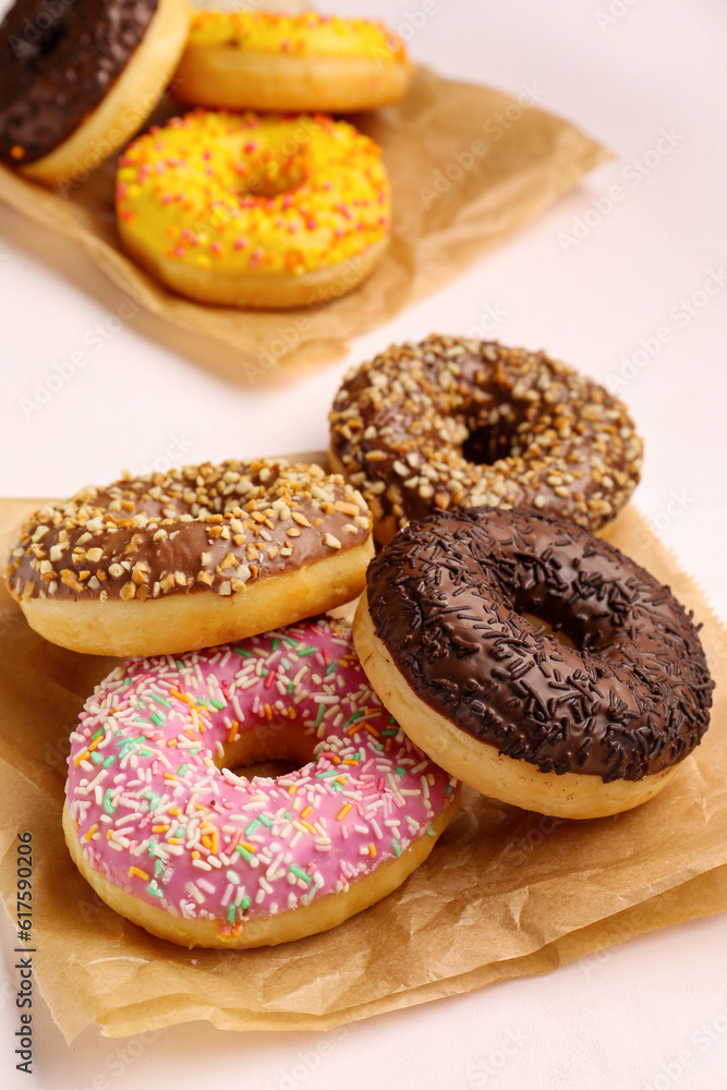 Paper bags with sweet donuts on white background