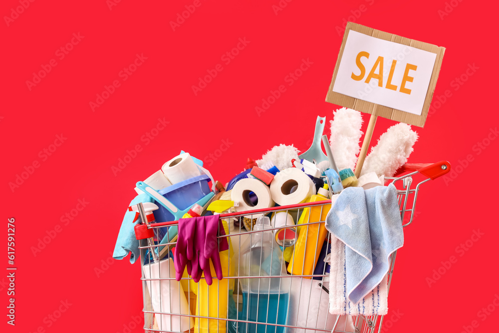 Shopping cart full of cleaning supplies with word SALE on red background