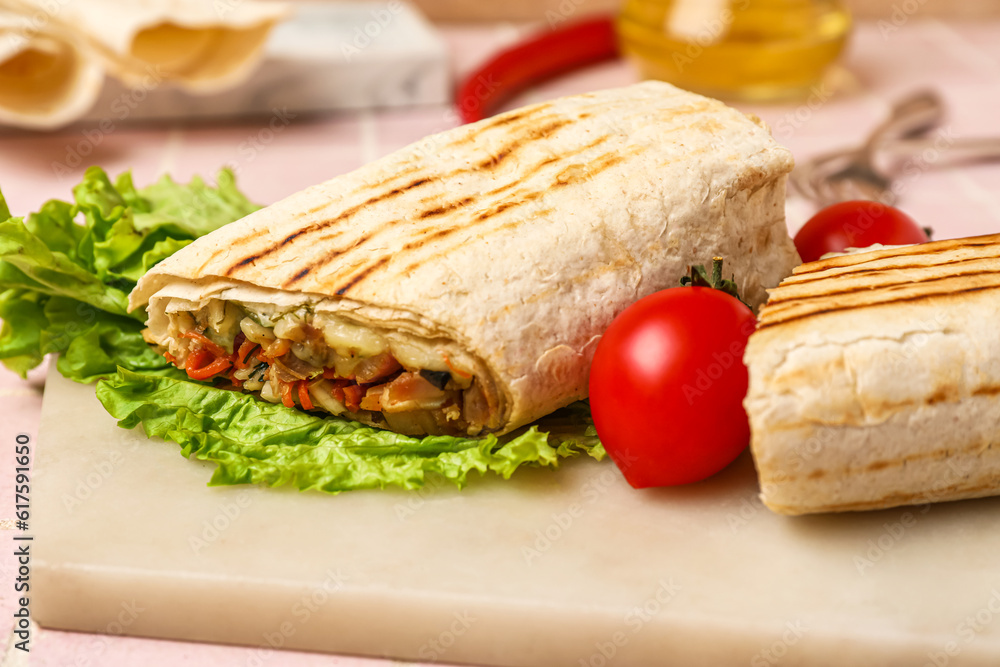 Board of tasty shawarma with lettuce and tomatoes on table