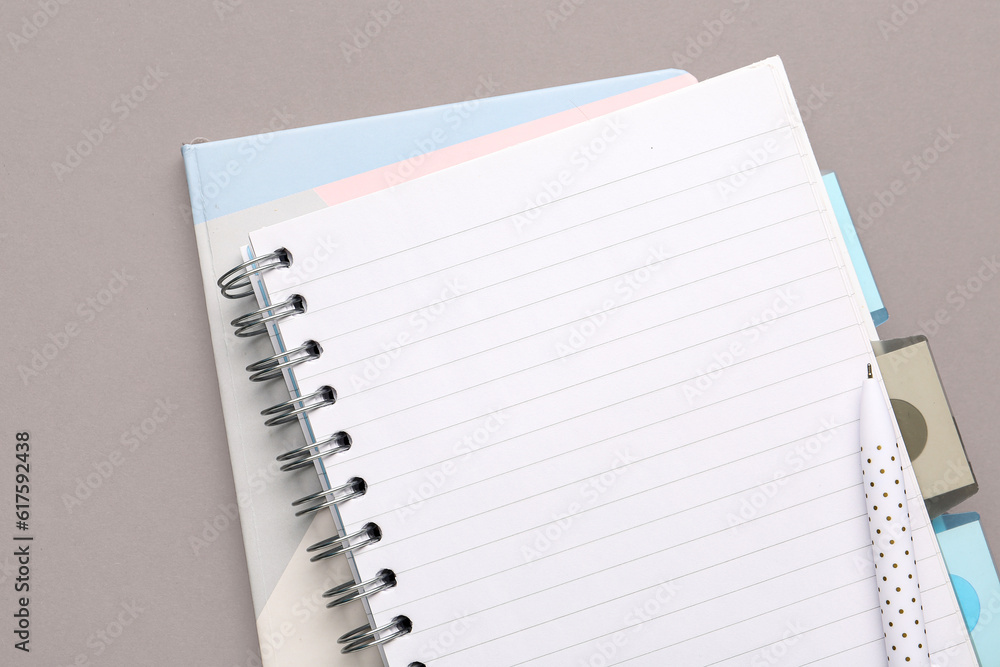 Notebooks and pen on grey background, closeup