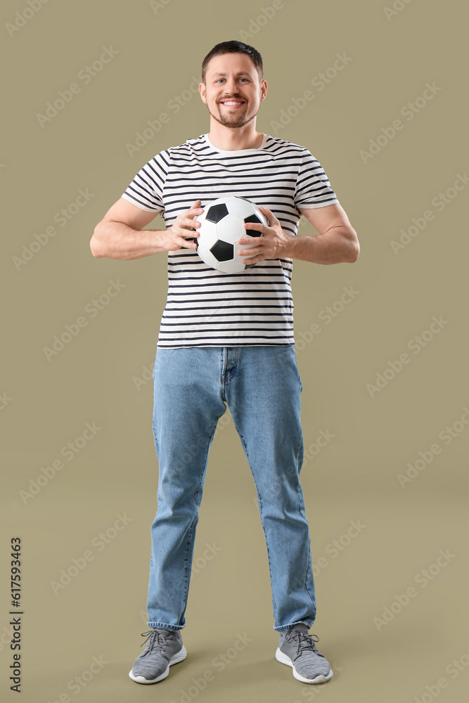 Happy man with soccer ball on color background