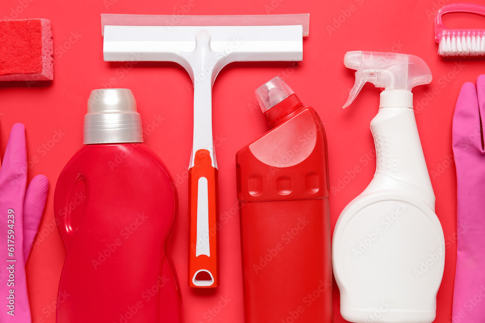 Different cleaning supplies on red background