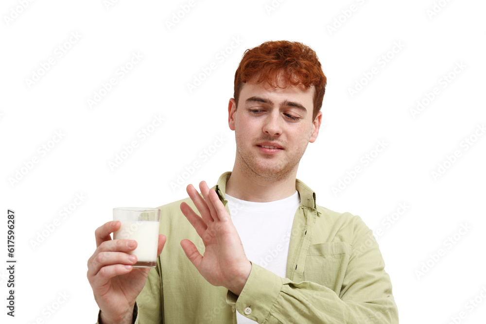 Displeased young man rejecting glass of milk on white background