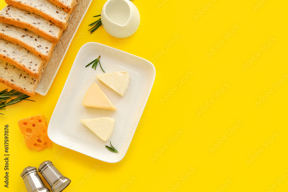 Plates with triangles of tasty processed cheese and toasts on yellow background