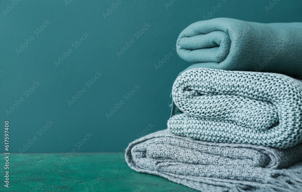 New soft folded blankets on green background, closeup