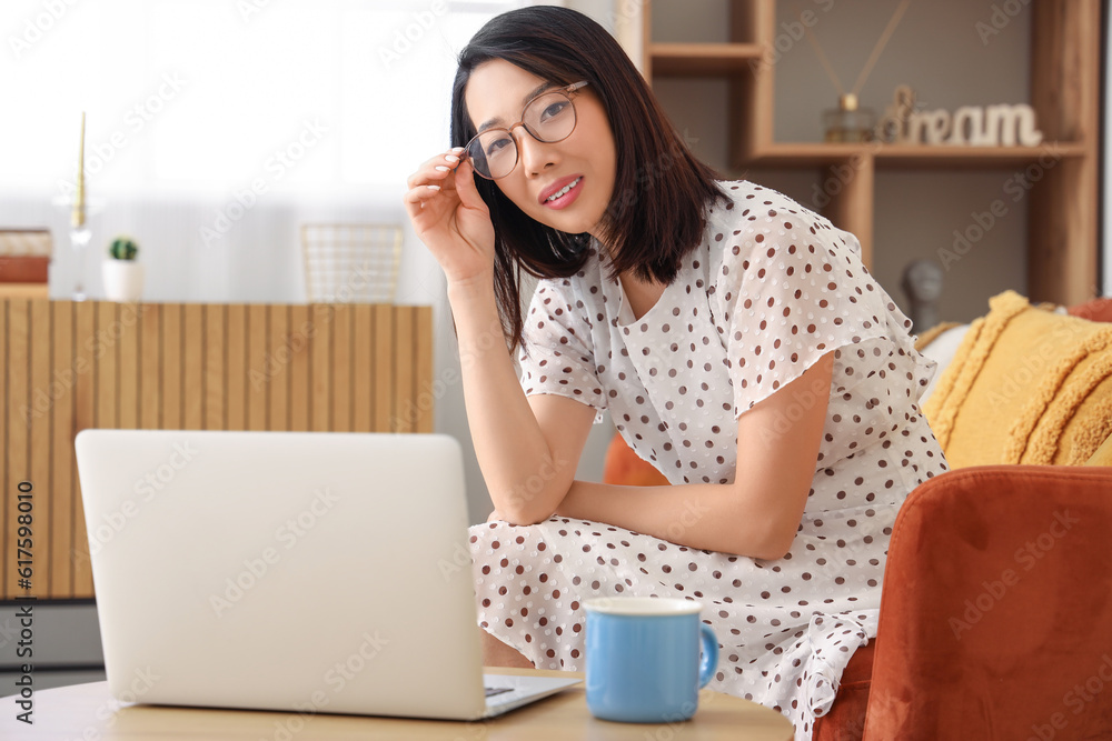 Beautiful Asian woman in stylish eyeglasses at home